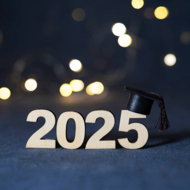 Tahta numara 2025. Mezuniyet şapkası koyu arka planda ve Bokeh ile birlikte. 2025 sınıfı konsepti