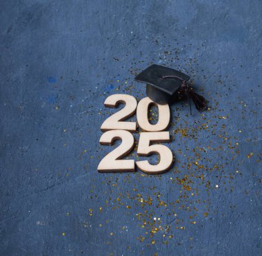 Koyu arkaplanda 2025 numaralı tahtanın mezuniyet şapkası. 2025 sınıfı konsepti.