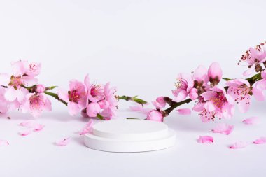 Bahar beyazı podyum veya kaide ve pembe çiçek açısı görünümü.