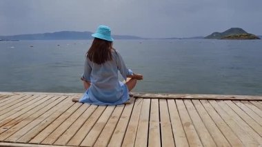 Deniz kıyısında meditasyon yaparken huzurlu bir anın tadını çıkarıyorum.