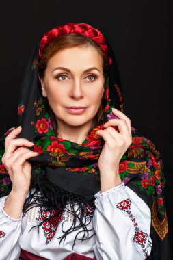 Ulusal kostümlü güzel Ukraynalı kadın. Çekici Ukraynalı kadın geleneksel Ukrayna nakışlarıyla siyah arka planda.