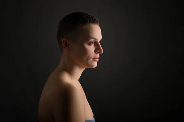 黒地に短い髪と裸の肩を持つ若い女性の肖像画 — ストック写真