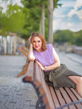 Güzel orta yaşlı kadın sokak fotoğraf çekiminde poz veriyor.