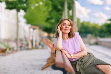 Güzel orta yaşlı kadın sokak fotoğraf çekiminde poz veriyor.