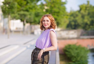 Güzel orta yaşlı kadın sokak fotoğraf çekiminde poz veriyor.