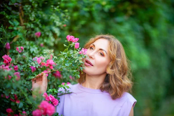 Hermosa Mujer Mediana Edad Exitosa Oliendo Rosas Florecientes Disfrutando Jardín —  Fotos de Stock