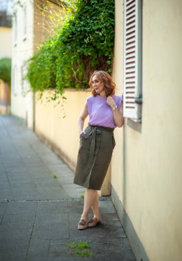 Güzel orta yaşlı kadın sokak fotoğraf çekiminde poz veriyor.