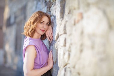 Güzel orta yaşlı kadın sokak fotoğraf çekiminde poz veriyor.