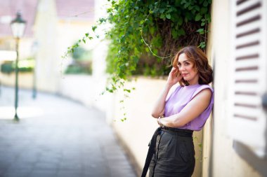 Güzel orta yaşlı kadın sokak fotoğraf çekiminde poz veriyor.