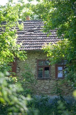 Kırık pencereli ve çatılı terk edilmiş bir ev.