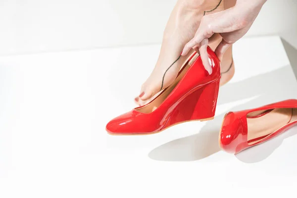 穿着红衣服 脚上穿着红鞋子 脚上穿着旧式茶色长袜的年轻女子 免版税图库图片