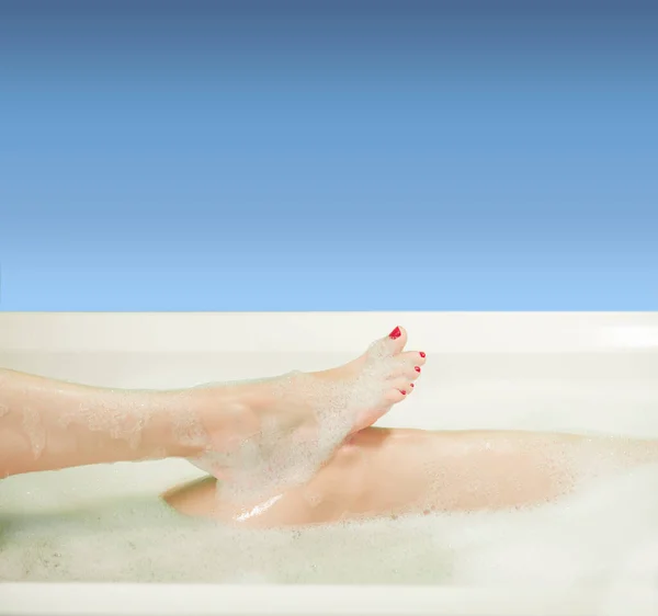 年轻女子的手和脚被白浴中的泡沫覆盖着 — 图库照片