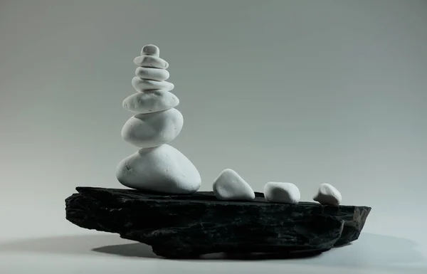 Weiße Glatte Steine Balanciert Auf Einem Schwarzen Flachen Stein Stockfoto
