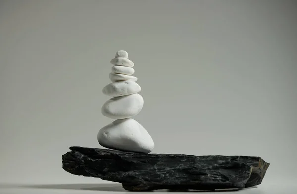 Білі Гладкі Камені Збалансовані Над Одним Чорним Плоским Каменем Ліцензійні Стокові Зображення