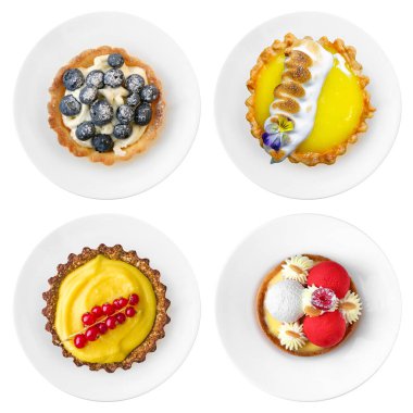 Beyaz arka planda izole edilmiş tabakta lezzetli meyve ve kek tatlısı. Şekerlemeci gıda koleksiyonu düz bir görünüm yatıyordu