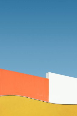 Mavi gökyüzüne karşı duvar inşa etmenin renkli şekli, soyut minimalist mimari