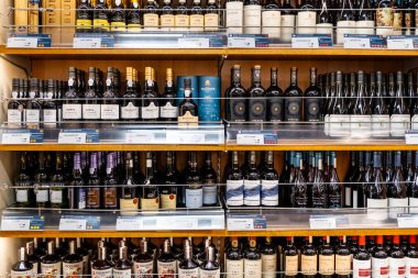 Helsinki, Finlandiya - 09 Ağustos 2022: Bir dükkanda rafa dizilmiş şarap şişelerine yakın çekim, içki dükkanında satılık alkol