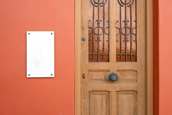 玄関のドアによる壁の屋外ビジネス看板の長方形のモックアップ ロイヤリティフリーのストック写真