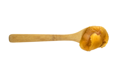 Tahta kaşıkta taze bal izole edilmiş.