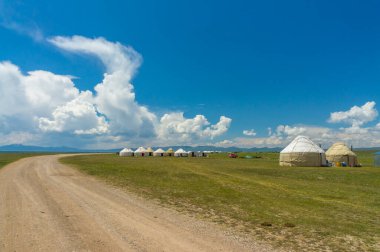 Kırgızistan 'da, sakin Son-Kul Gölü kıyısında bir turist yurdu kampı var. Geleneksel göçebe sığınakları geniş otlakları görkemli dağların ve süpüren bulutların arka planına karşı doldurur..