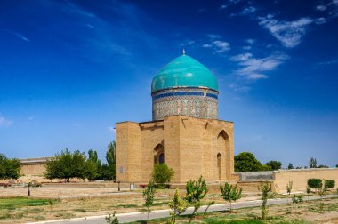 Turkuaz kubbe, Rabigha Sultan Begim Mausoleum 'u taçlandırıyor. Kaligrafi bantlarıyla örülmüş, açık bir günde gökyüzüne karşı dizilmiş, Sheibanid döneminden kalma kalıcı bir yapı..