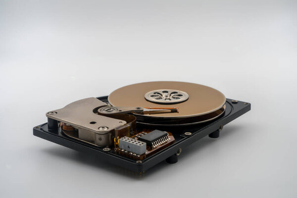 Hard disk drive HDD, circular magnetic disk, platters. Central spindle, actuator arm with read write head, circuit board. Precision device for data storage, mechanical and electronic components