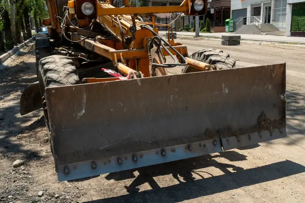 Büyük sarı dereceli makineler düzleştirme ve yol yatağını düzleştirme, yeni asfalt kaldırım için temel katman hazırlama, modern yol altyapısı ve sokak iyileştirmesinde önemli bir adım.