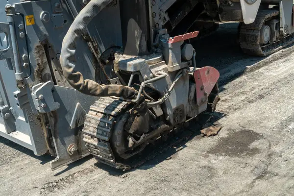 Asfalt değirmen ekipmanları sürüngen raylı, dönen davul ve taşıma sistemi bozulmuş yol yüzeyini kaldırıyor, kentsel altyapıda yeni asfalt uygulaması için temel hazırlıyor.