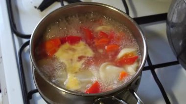Rus köfteleri metal bir tavada pişirilir. Tavadaki malzemeler Pelmeni, havuç ve tatlı biber. Ekşi kremayla servis edilir..