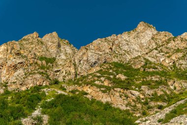 Dik engebeli uçurumlar yoğun bitki örtüsünün üzerine yükselir, yürüyüş, tırmanma, açık hava keşfi, doğa keşfi ve uzak dağlık arazide dağlık alan macerası için mükemmel dramatik bir manzara oluşturur..