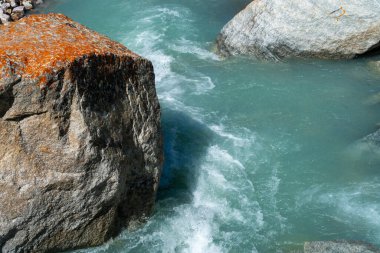 Ala-Archa Parkı, berrak mavi suyla hızlı akan buzul deresi, engebeli kayalar ve vahşi arazi, el değmemiş doğa, açık hava macerası ve zorlu dağ seyahati ortamlarını temsil ediyor..