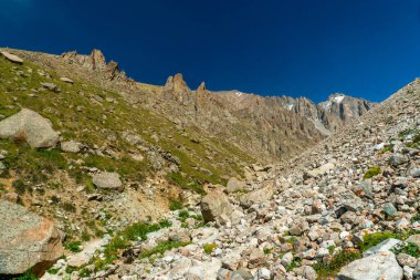 Ala-Archa Dağı manzarası kayalık arazi, dik yamaçlar, dik yamaçlar ve uzak çayırlık zirveler yürüyüş, dağcılık, taşra yürüyüşü, macera gezileri için idealdir..