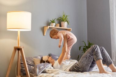 Tatmin olmuş anne ve kızının yatak odasında oynaşırken çekilmiş bir portresi. Anne kucağında küçük kızı, mutluluğunu ifade ediyor..