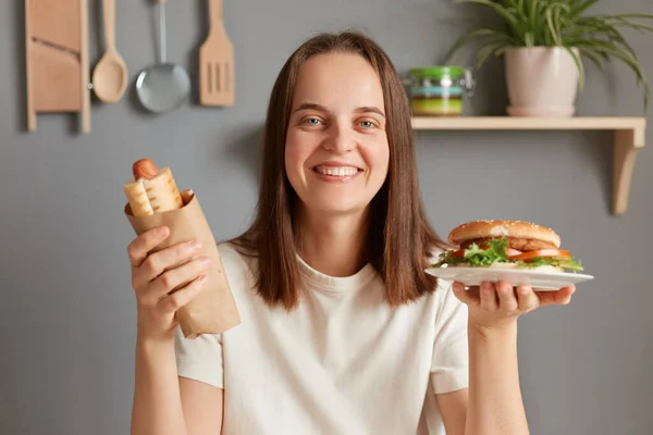 Indoor Shot Woman Sitting Kitchen Holding Hot Dog Ans Sandwich — Stockfoto