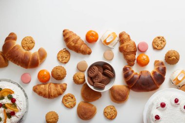 Pişirme arka planı. Şekerli tatlılardan, keklerden, kurabiyelerden, kruvasanlardan, masada çöreklerden oluşan düz bir yatak. Metin alanı, üst görünüm.