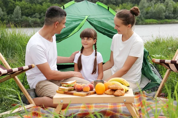 男人和女人坐在地上的帐篷边 和女儿一起野餐 共度快乐的周末 — 图库照片