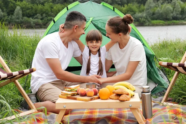 妈妈和爸爸都喜欢坐在河边 坐在帐篷边 享受着快乐的周末 父母和孩子拥抱在一起 表达着快乐的感觉 — 图库照片