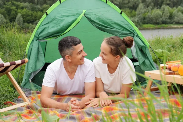 大自然中快乐的一对 穿着休闲装的女人和男人躺在河边的帐篷里 度假愉快 周末浪漫 彼此交流愉快 — 图库照片