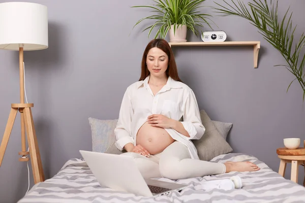 Concentrado Embarazada Cabello Castaño Caucásico Mujer Sentada Cama Delante Computadora — Foto de Stock