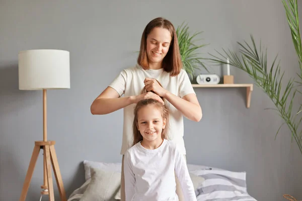 Positive Cheerful Mother Making Hairstyle Her Daughter While Sitting Bed — Stock Photo, Image