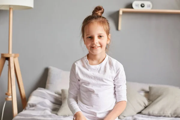 Positive Little Girl Sitting Bed Smiling Kid Bun Hairstyle Wearing — Stock Photo, Image
