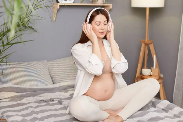 Hermosa Joven Embarazada Escuchando Música Casa Con Auriculares Con Ropa — Foto de Stock