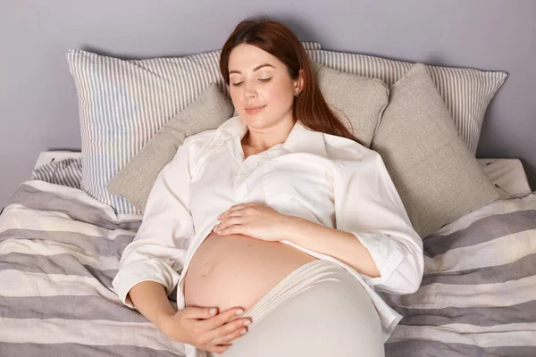 Mujer Embarazada Contenta Descansando Tranquilamente Cama Casa Con Camisa Blanca — Foto de Stock