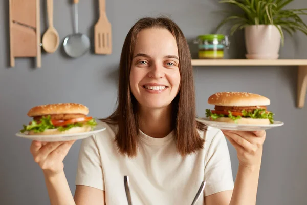 Nezdravé Jídlo Krásná Pozitivní Dívka Usmívá Kameru Pózuje Dvěma Chutnými — Stock fotografie