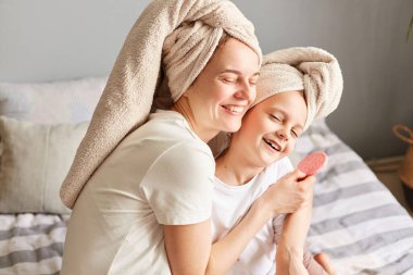 Sevimli anne ve kızı, sabahları kafalarında havluyla, cilt bakımı ameliyatları yaparken kaplıcalara gidip, sevgilerini ifade ediyorlar..