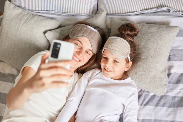 Gülümseyen Neşeli Kadının Kızının Sabah Uyandığında Cep Telefonuyla Selfie Çekerek — Stok fotoğraf