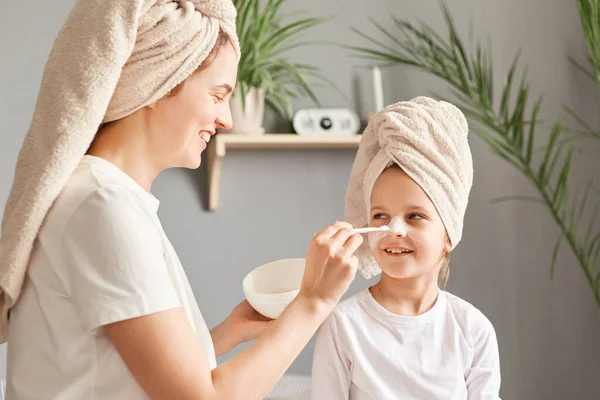水疗日 家庭时间 母亲和女儿在做美容术的过程中一起呆在家里 给女儿戴口罩 享受美容术的日常生活 — 图库照片
