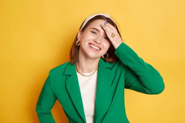 Piękna Zachwycona Kobieta Zielonej Kurtce Trzyma Rękę Czole Uśmiechając Się — Zdjęcie stockowe