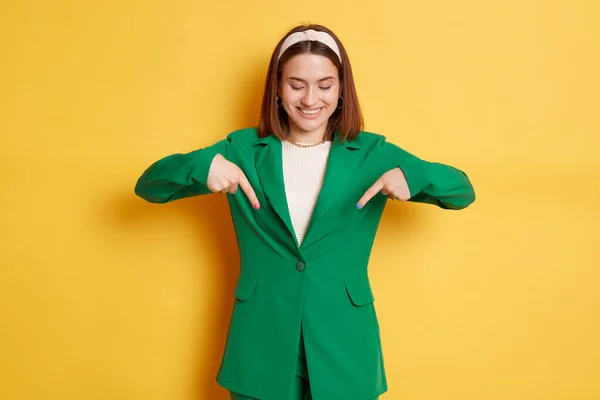 Улыбающаяся Радостная Женщина Зеленой Куртке Стоящая Изолированно Желтом Фоне Указывая — стоковое фото