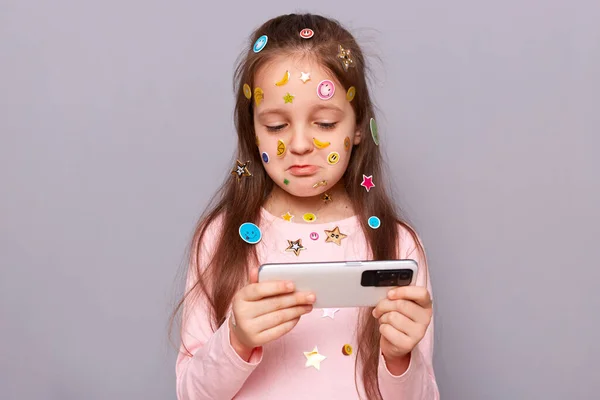 Sad Little Girl Smartphone Standing Isolated Gray Background Covered Colorful — Stock Photo, Image